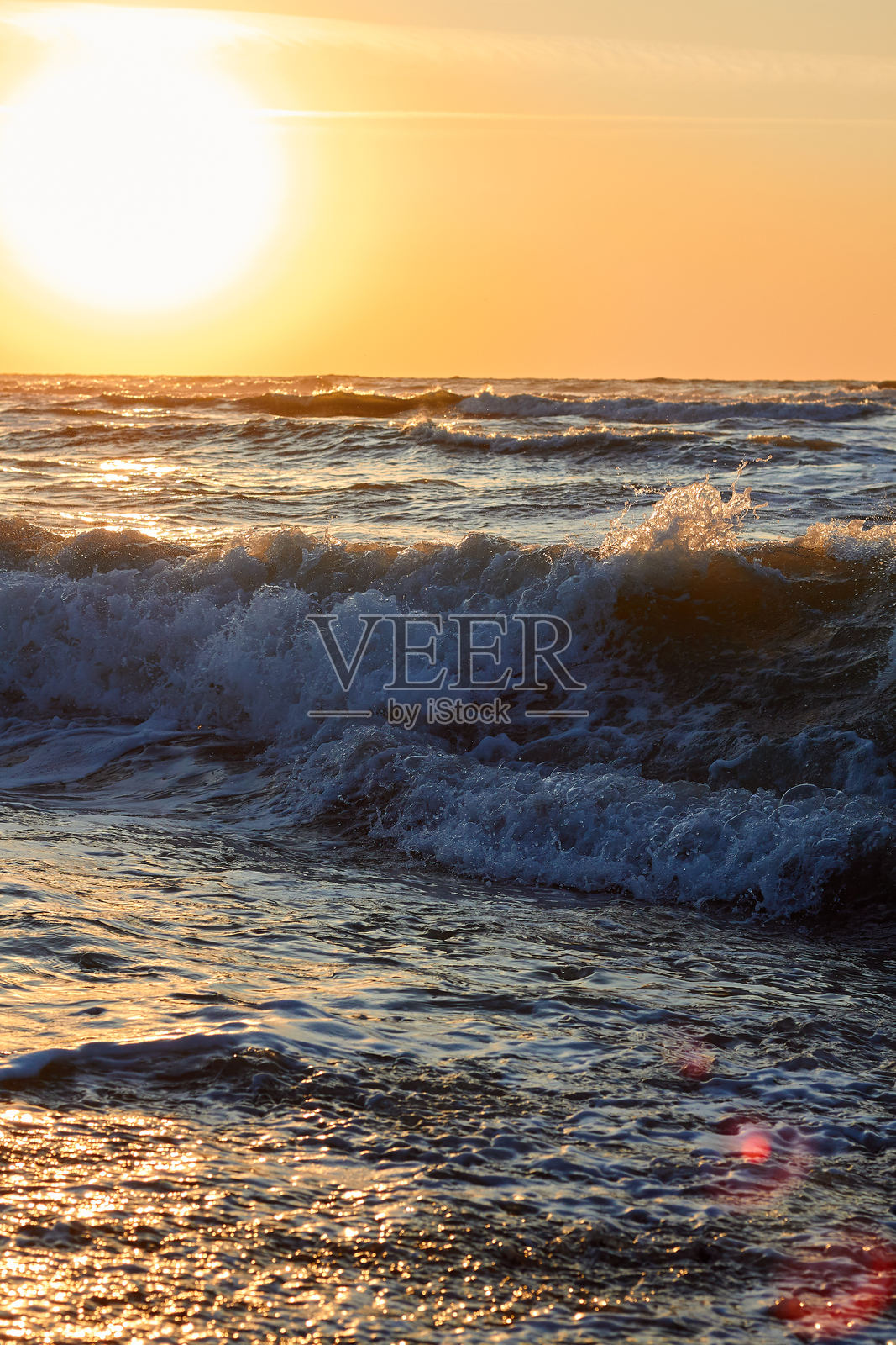 美丽的海浪伴随着大量海泡沫冲击沙滩。特写镜头照片摄影图片