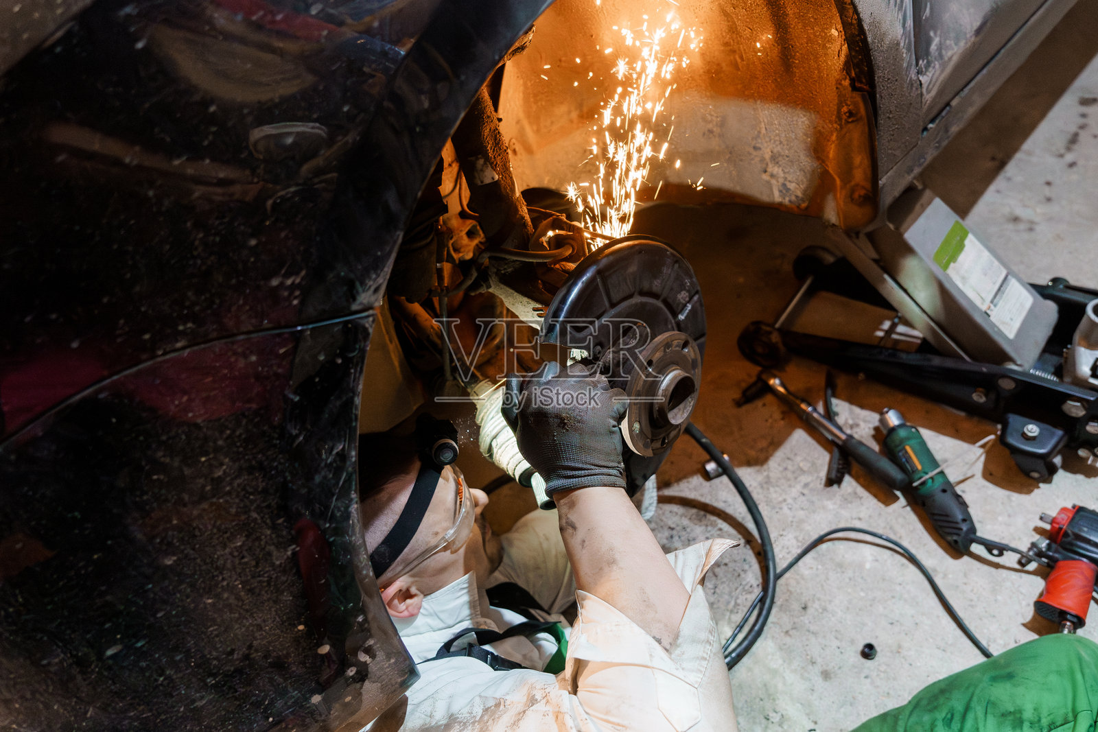 机械师在车库中进行刹车修理,火花四溅照片摄影图片