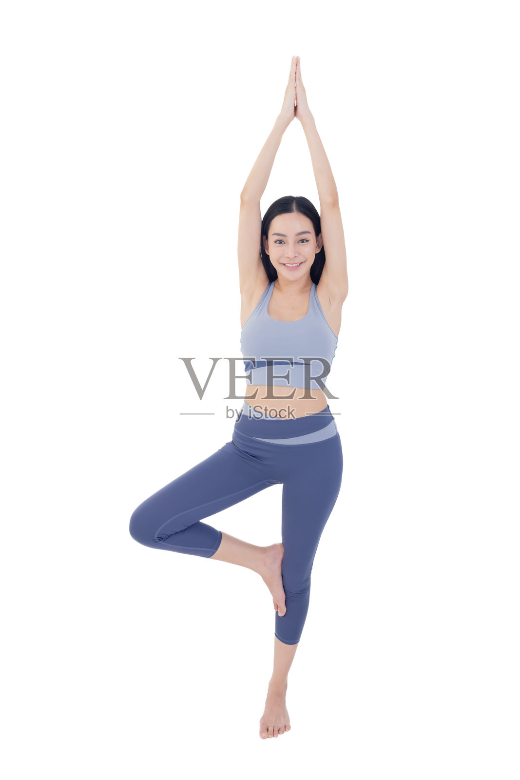 孤立的亚洲女性在白色背景上做树式瑜伽姿势照片摄影图片