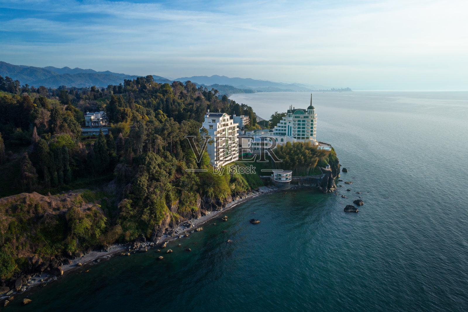 豪华海滨酒店的鸟瞰图,四周环绕着郁郁葱葱的绿树照片摄影图片