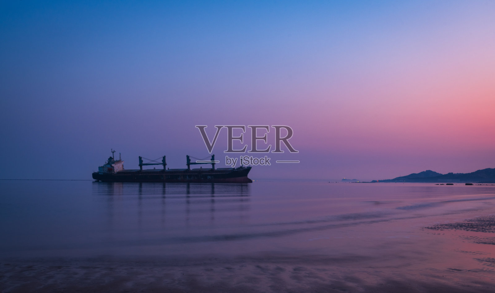 在微弱晨光下的广阔海面上的船只照片摄影图片