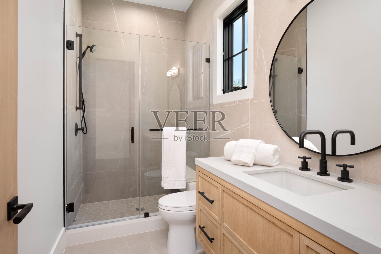 现代浴室配有玻璃淋浴和木质梳妆台照片摄影图片