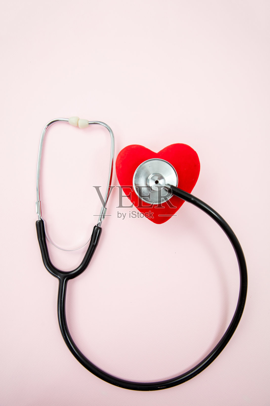 医疗听诊器和红色心脏在粉色背景上,健康日照片摄影图片