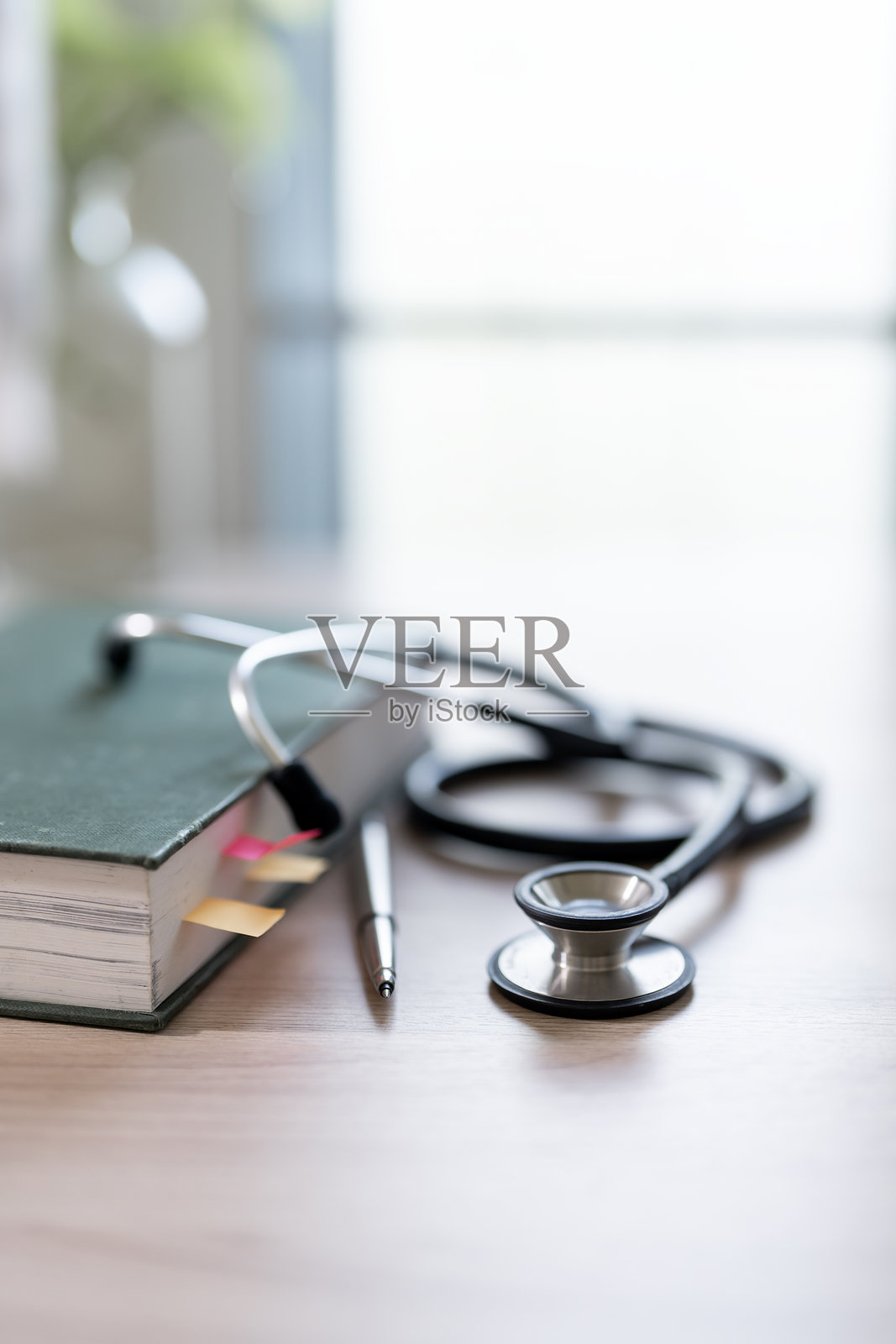 保健理念,听诊器和白色桌子上的书照片摄影图片