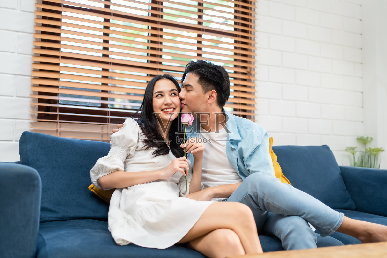 亚洲青年惊喜地送给美丽的女友玫瑰花。迷人浪漫的新婚夫妇男女花时间一起庆祝周年纪念日和情人节。照片摄影图片