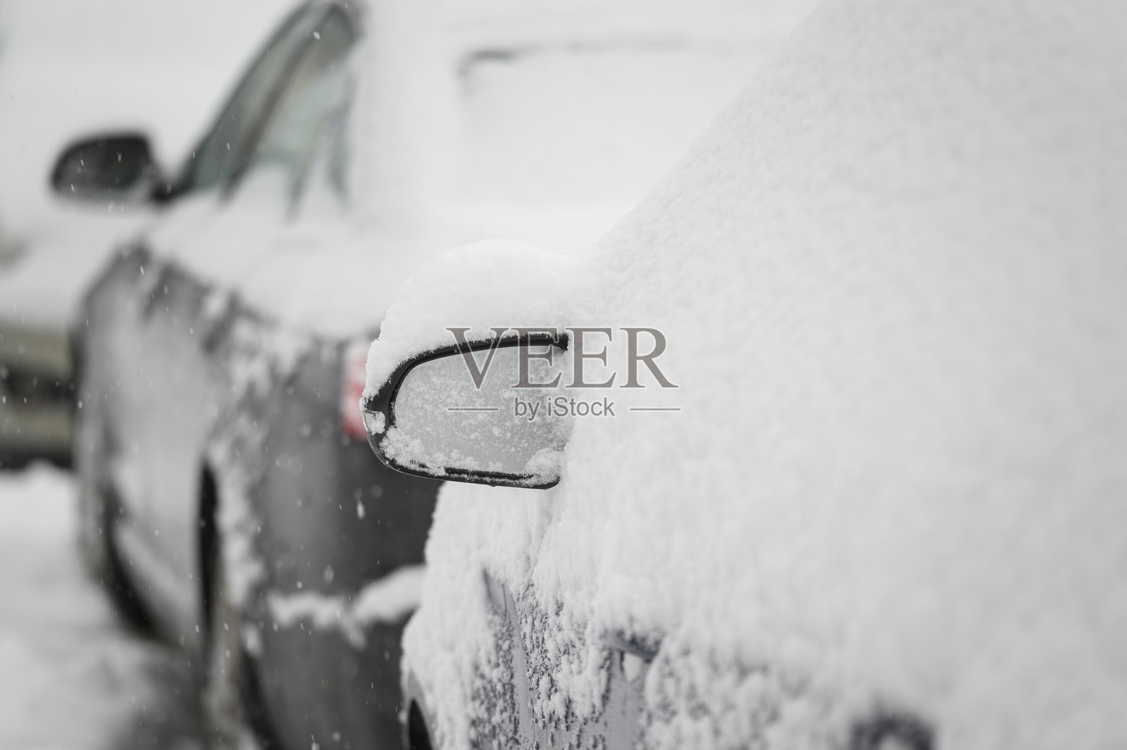 一场大雪过后,汽车被雪覆盖,特写。汽车雨刷起了。雪风暴。照片摄影图片