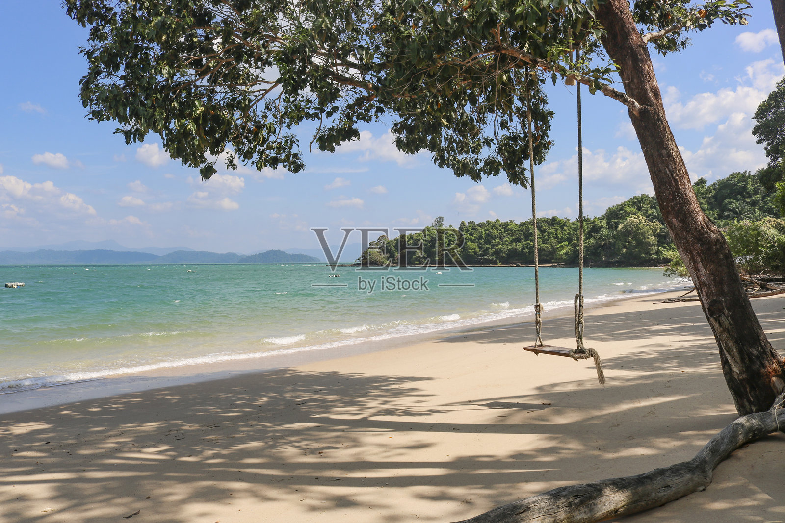 老绳木秋千的背景是美丽的蓝色大海,清澈碧蓝的海水。热带天堂,度假放松的好地方。照片摄影图片