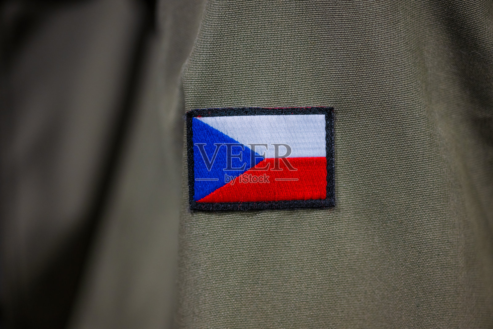 绿色军装上的徽章。照片摄影图片