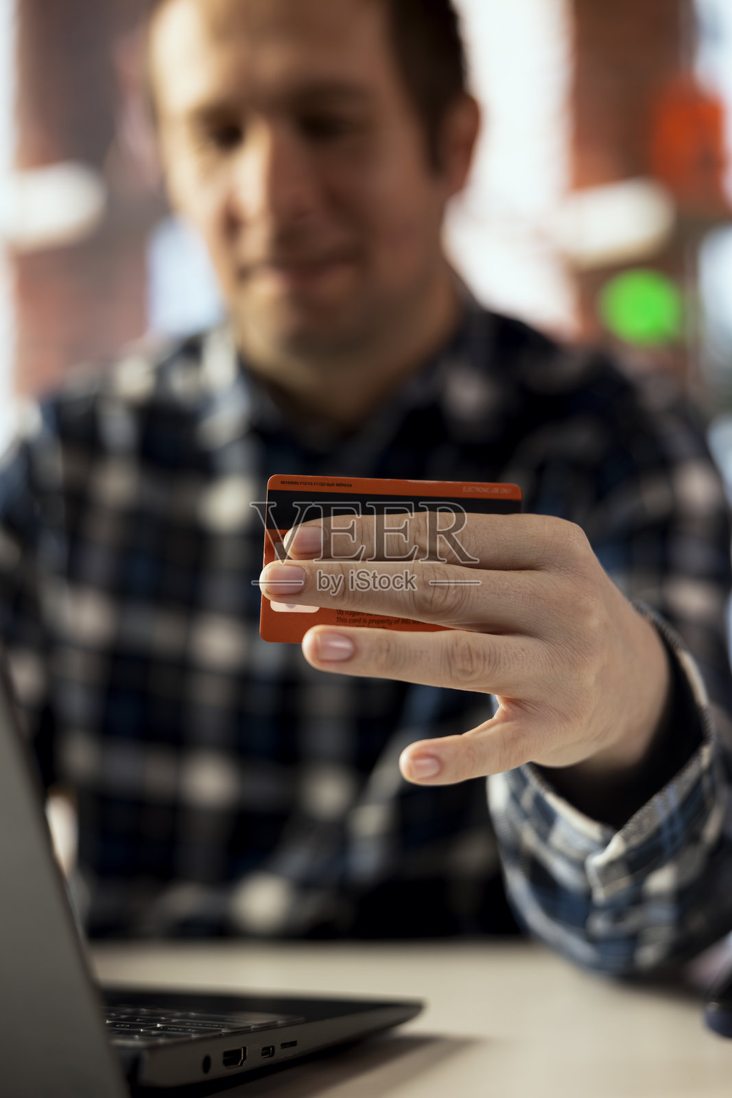 男子在公寓中使用信用卡支付账单的特写镜头照片摄影图片