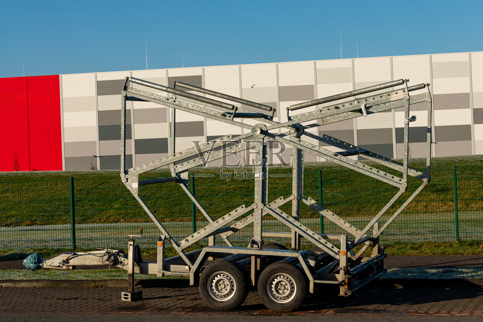 独特的金属拖车结构停靠在一栋色彩斑斓的建筑旁照片摄影图片