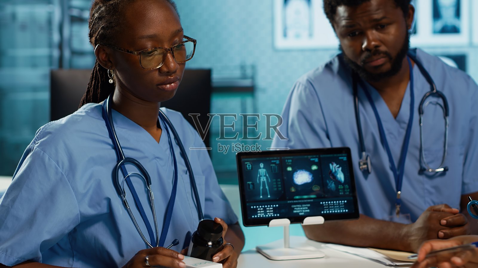 医生和助手在医疗办公室讨论药物和止痛药照片摄影图片