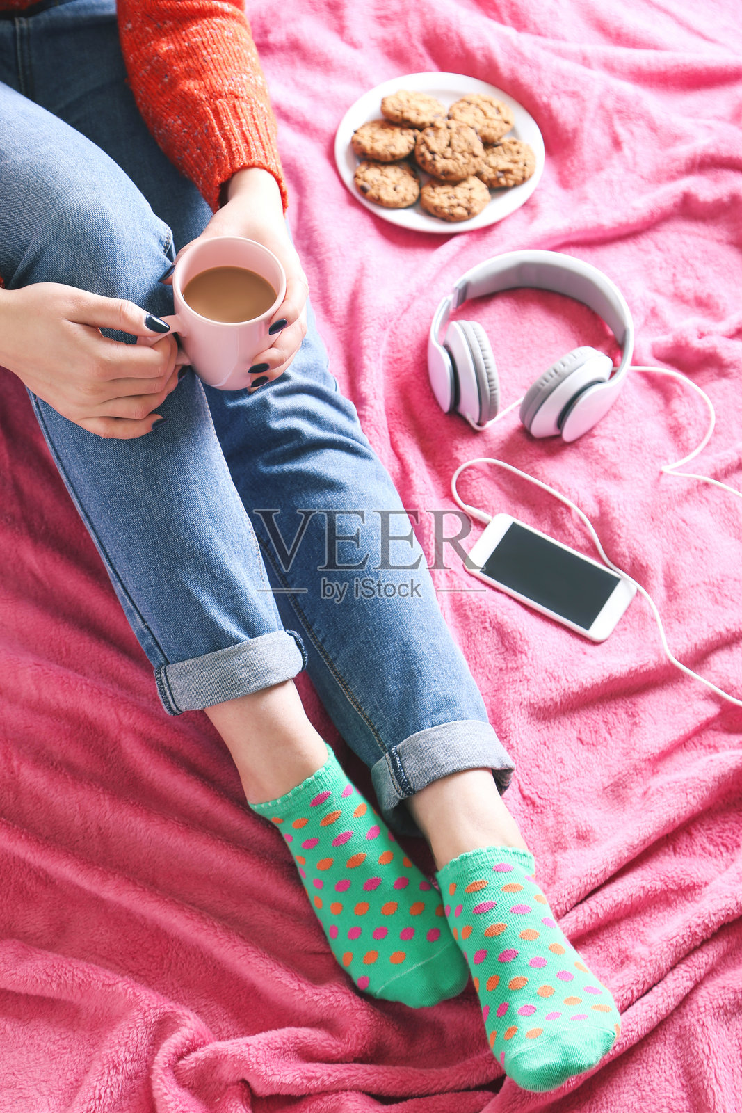 坐在粉色格子布上的女人手捧咖啡杯照片摄影图片