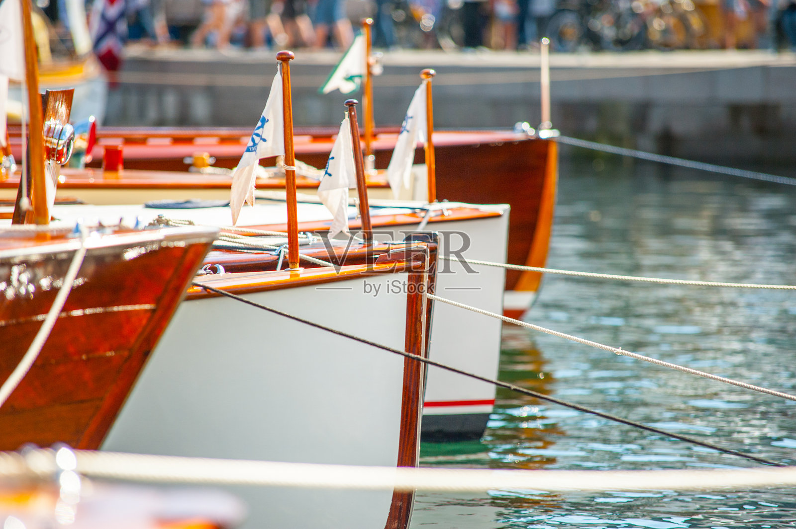 宁静的木船排在码头上,悬挂着蓝白相间的旗帜。照片摄影图片