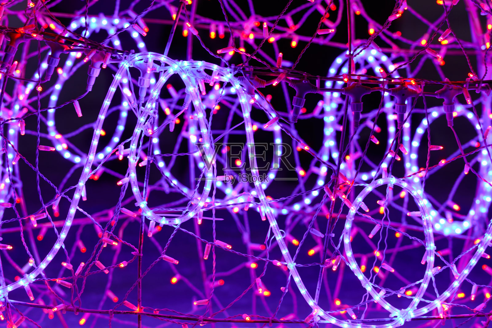 发光花环的特写灯光。紫丁香色的新年花环灯光。照片摄影图片