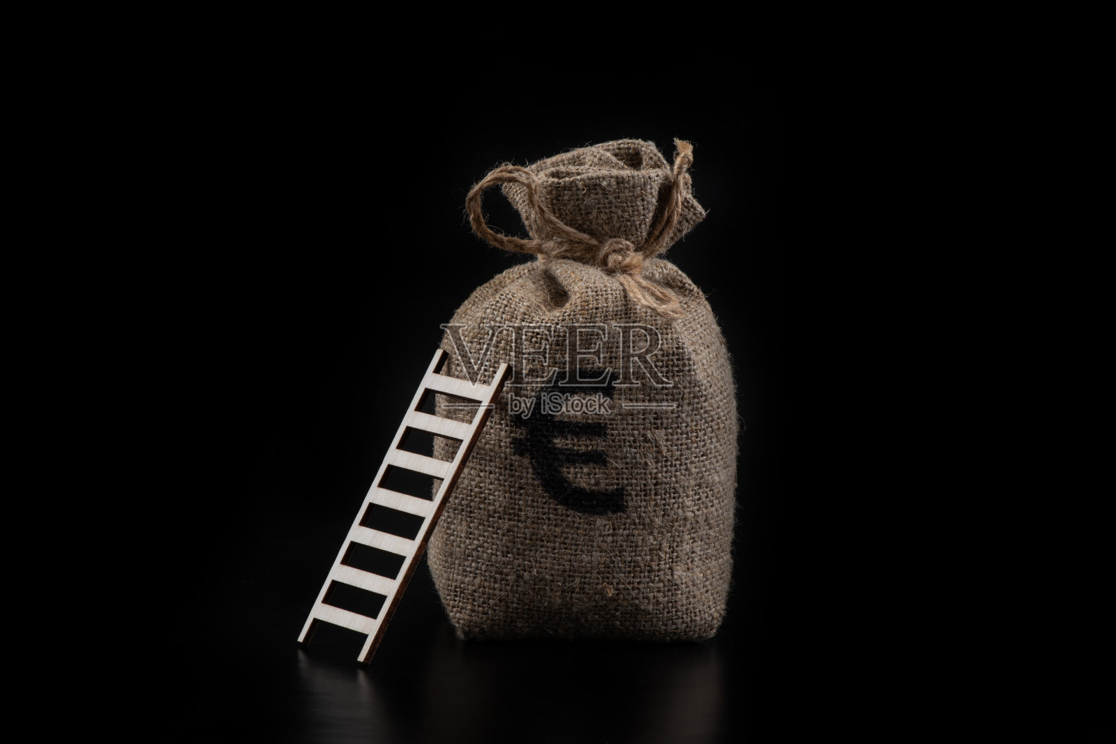 黑色背景上的伸缩梯和带有欧元符号的钱袋照片摄影图片