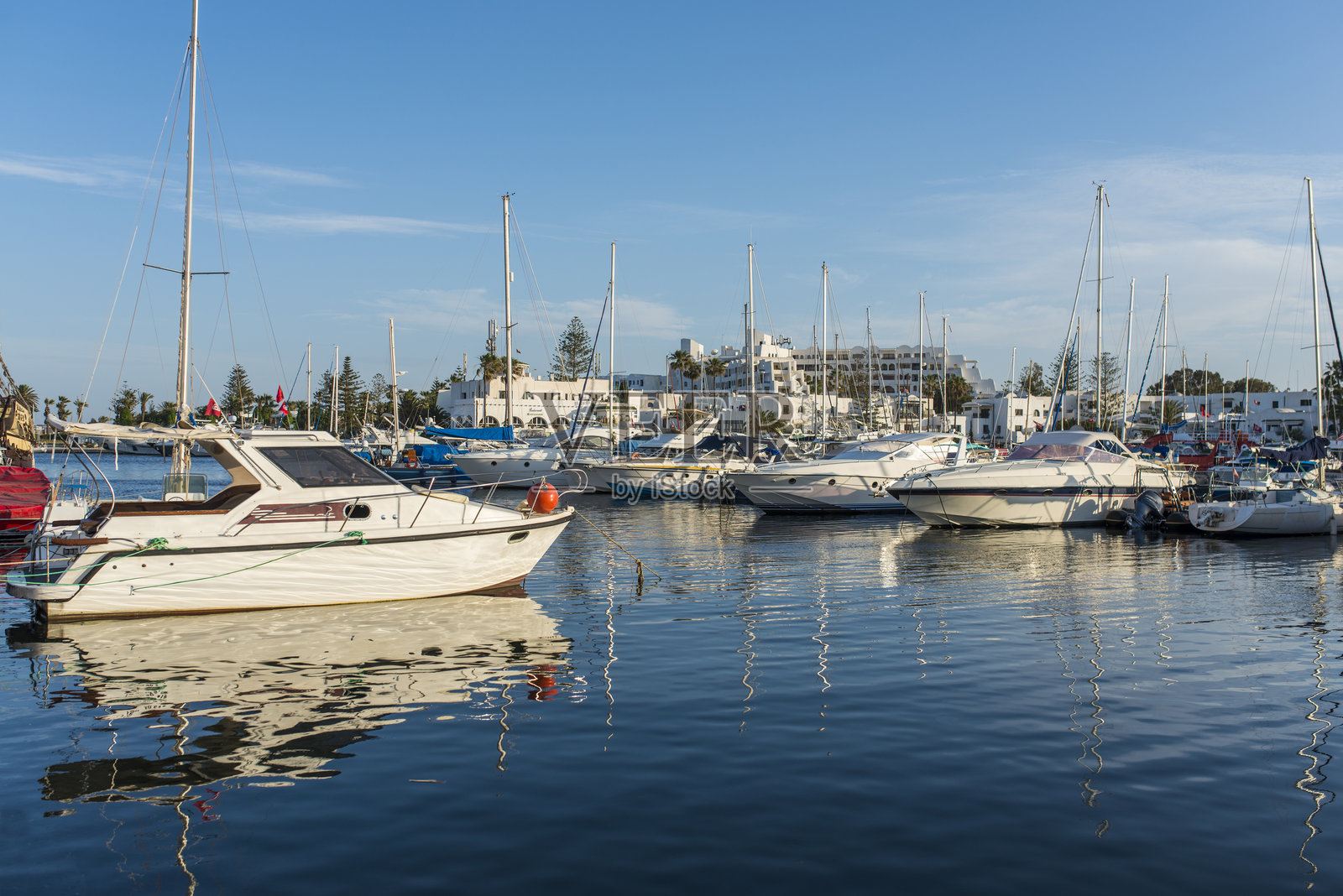 游艇和船只在码头的背景白色阿拉伯房子在蓝色的水,复制空间照片摄影图片