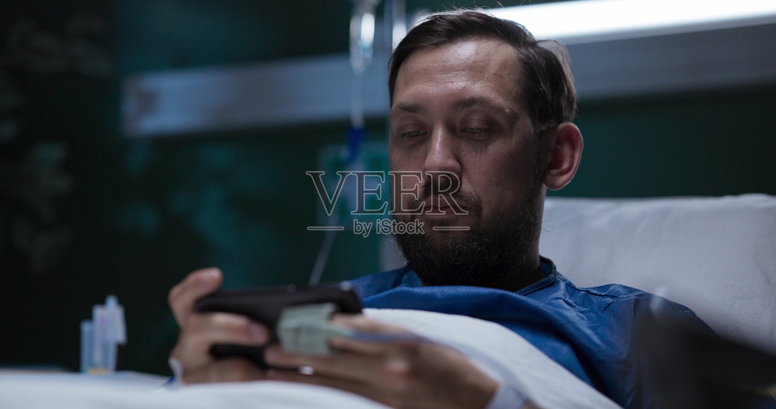 住院的人在手机上玩游戏,在虚拟世界中寻找娱乐照片摄影图片