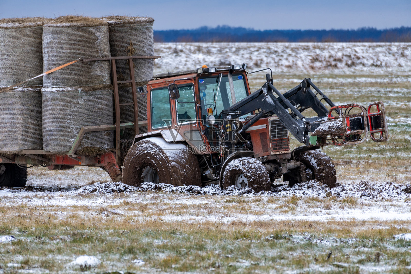 拖拉机陷入雪地泥潭 农民的困境:拖拉机在冬季田野中被困照片摄影图片