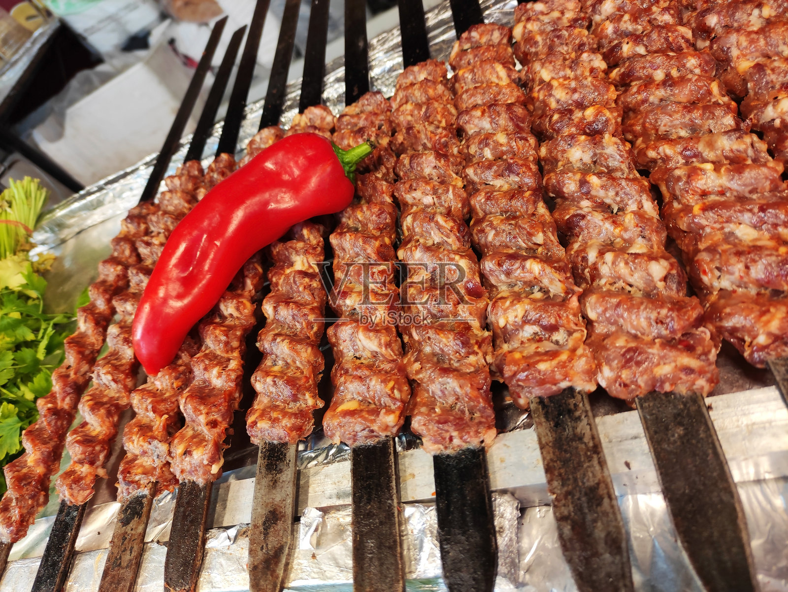 新鲜的烤肉饼串在烤架上烤制。照片摄影图片