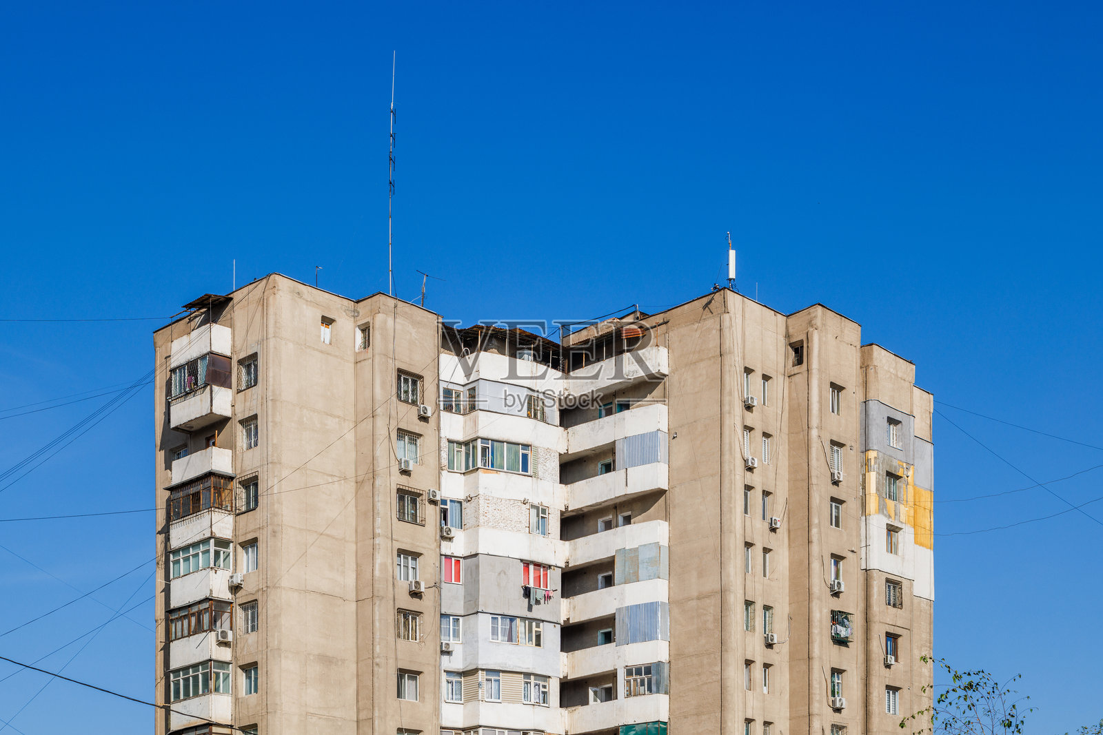 阳光明媚的日子里,破旧的多层公寓楼照片摄影图片
