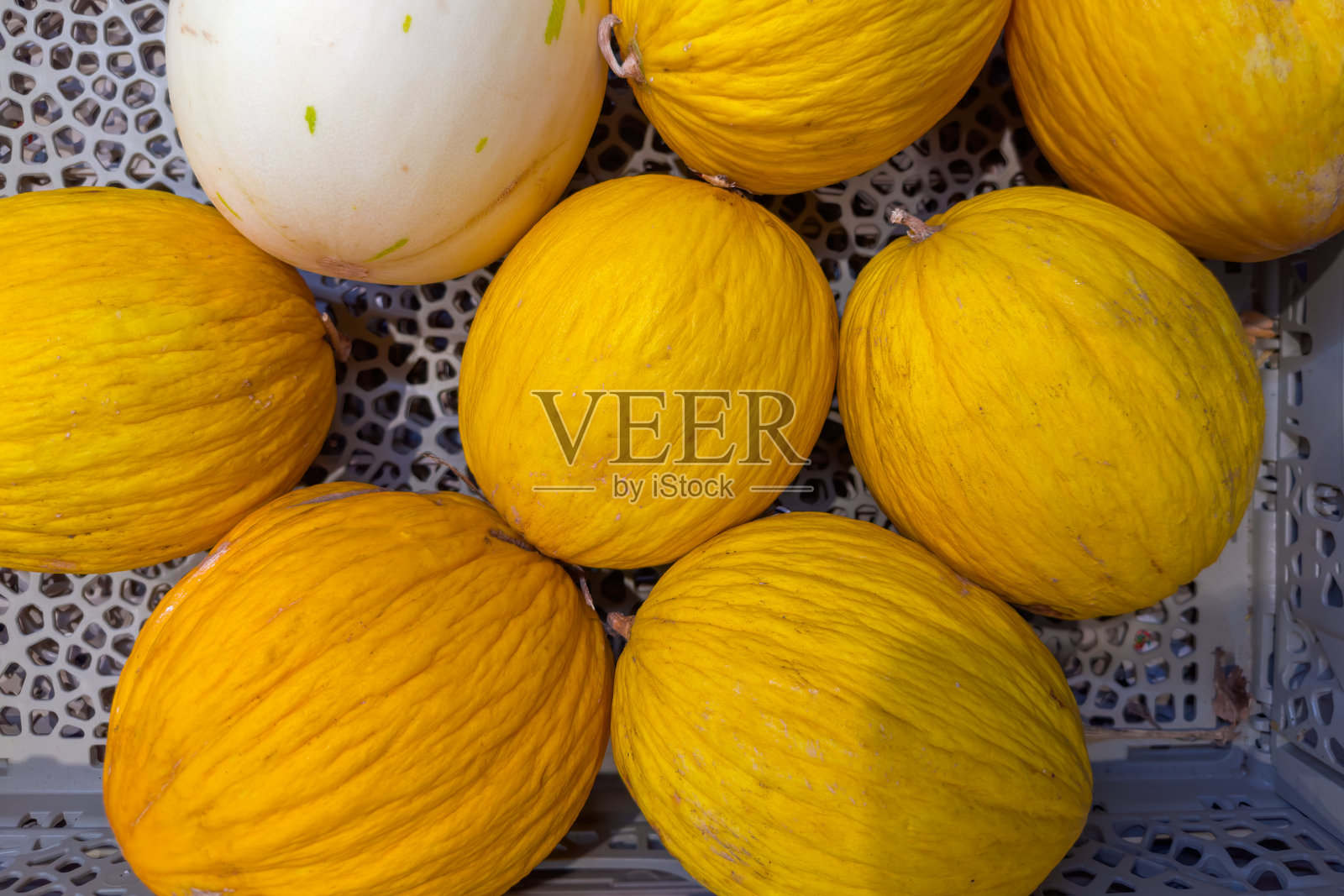 水果蔬菜市场中的塑料容器里的黄色西瓜照片摄影图片
