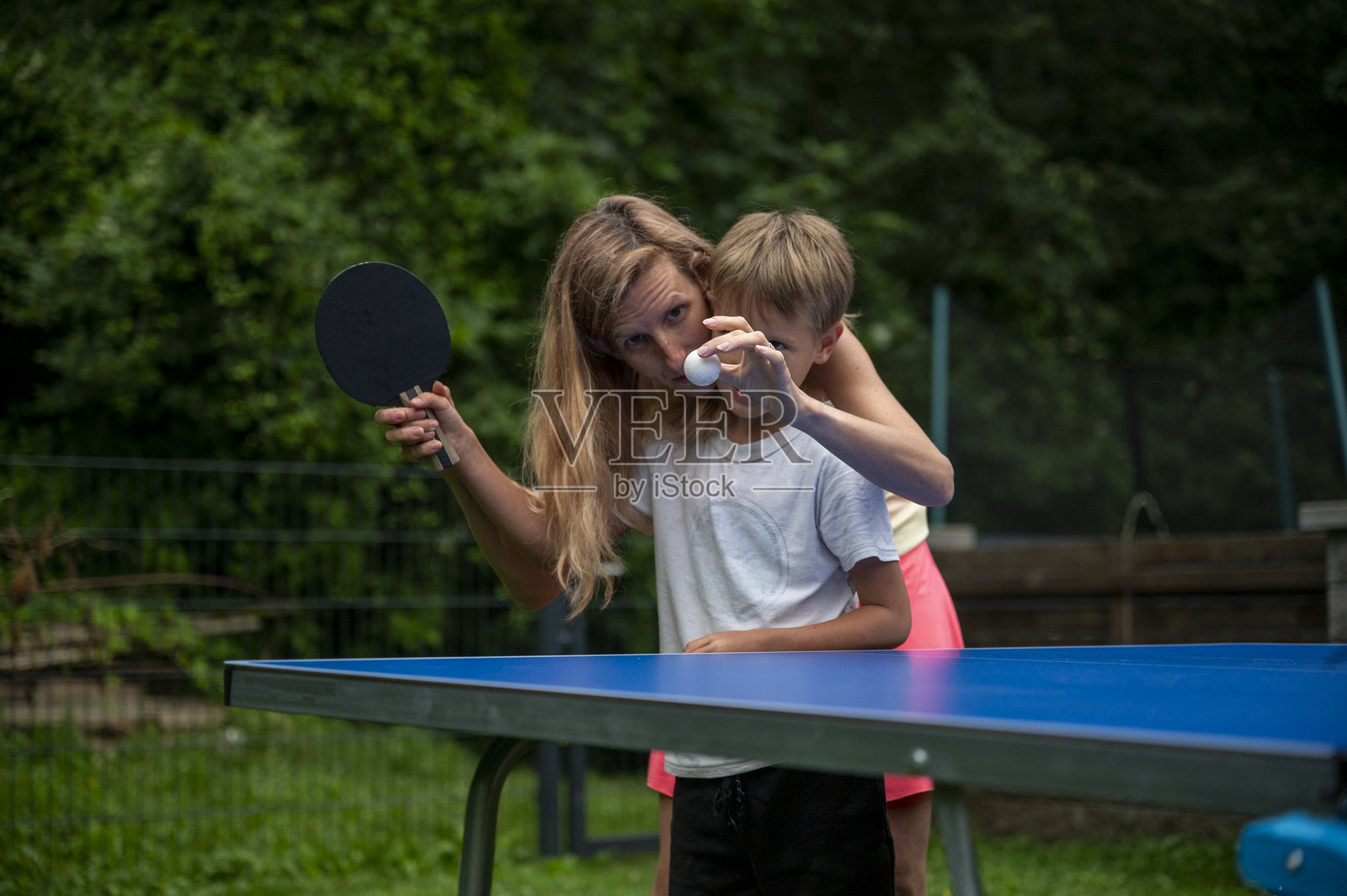 母亲在户外教儿子打乒乓球照片摄影图片