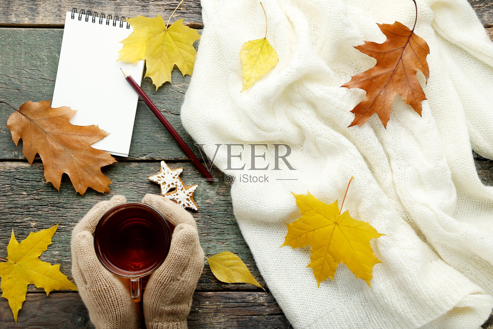 女性的手握着咖啡杯,放在木桌上照片摄影图片