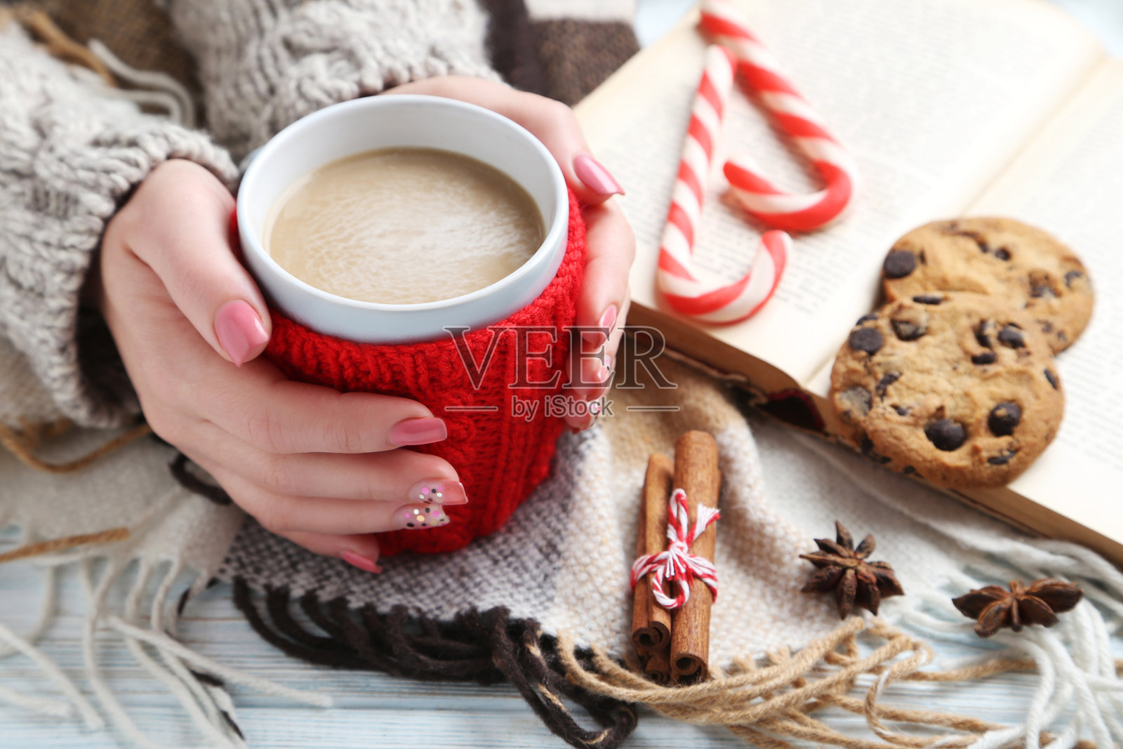 女人的手握着咖啡杯,放在木桌上照片摄影图片