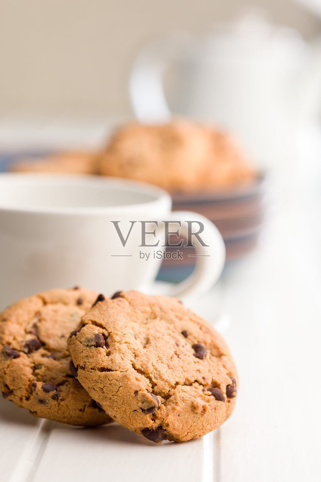 白色桌子上的巧克力曲奇饼干。照片摄影图片