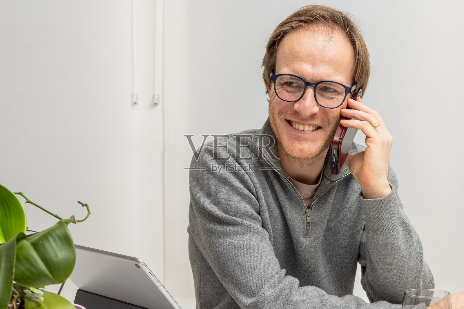 微笑的企业家在现代工作空间中进行商务电话沟通照片摄影图片