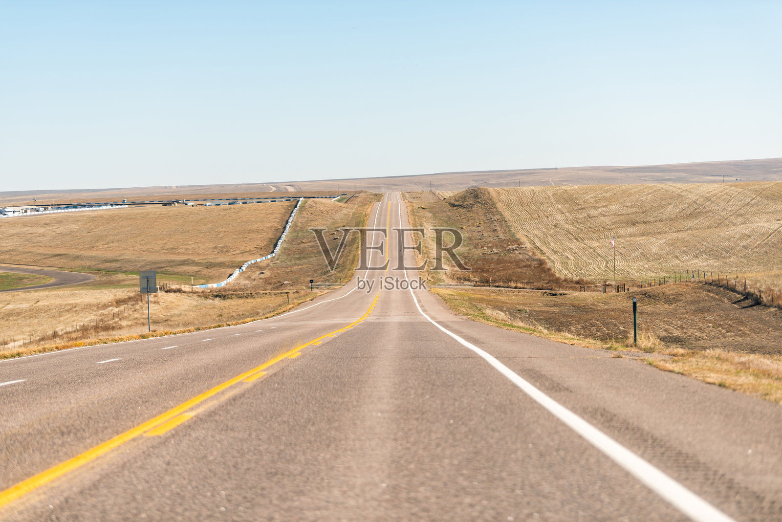 科罗拉多州的鹿道,沿着美国36号公路,荒凉的沙漠景观和蓝天,从驾驶视角看车行驶。照片摄影图片