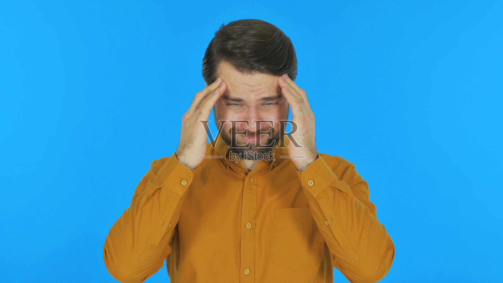 蓝色背景下的偏头痛男性肖像照片摄影图片