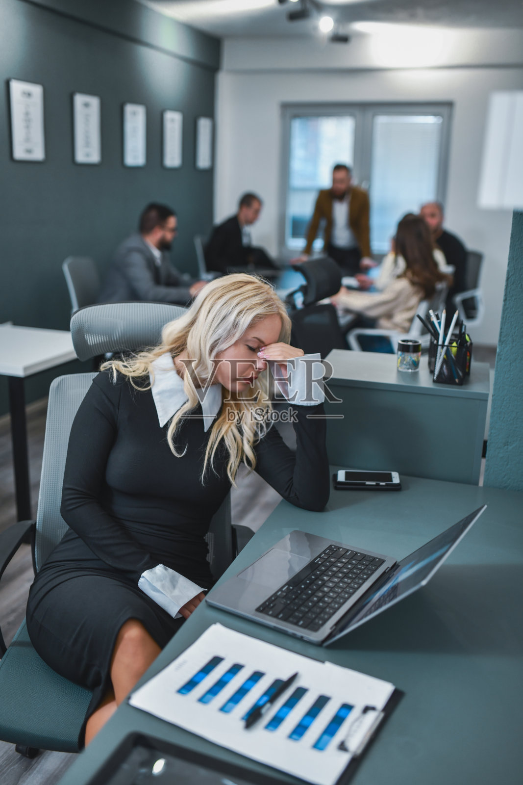 失望的女主管坐在办公室桌前,双手托着头,阅读负面的客户反馈。照片摄影图片
