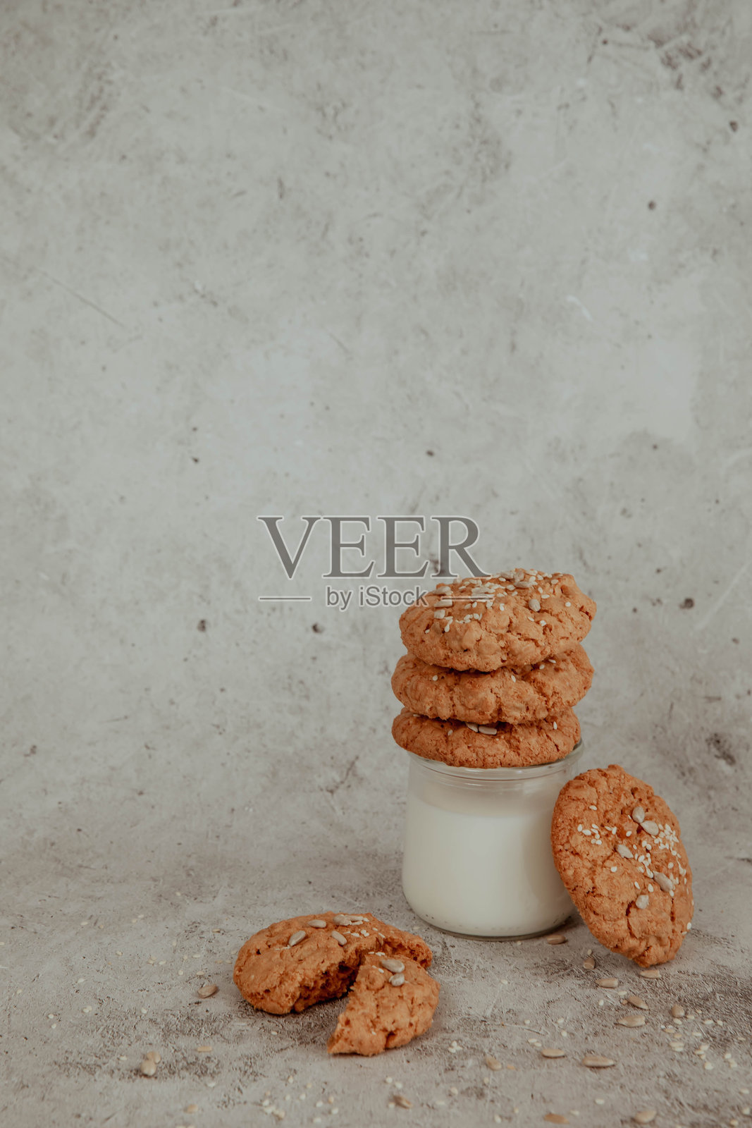 牛奶旁的燕麦饼干,背景明亮,洒落着碎屑照片摄影图片