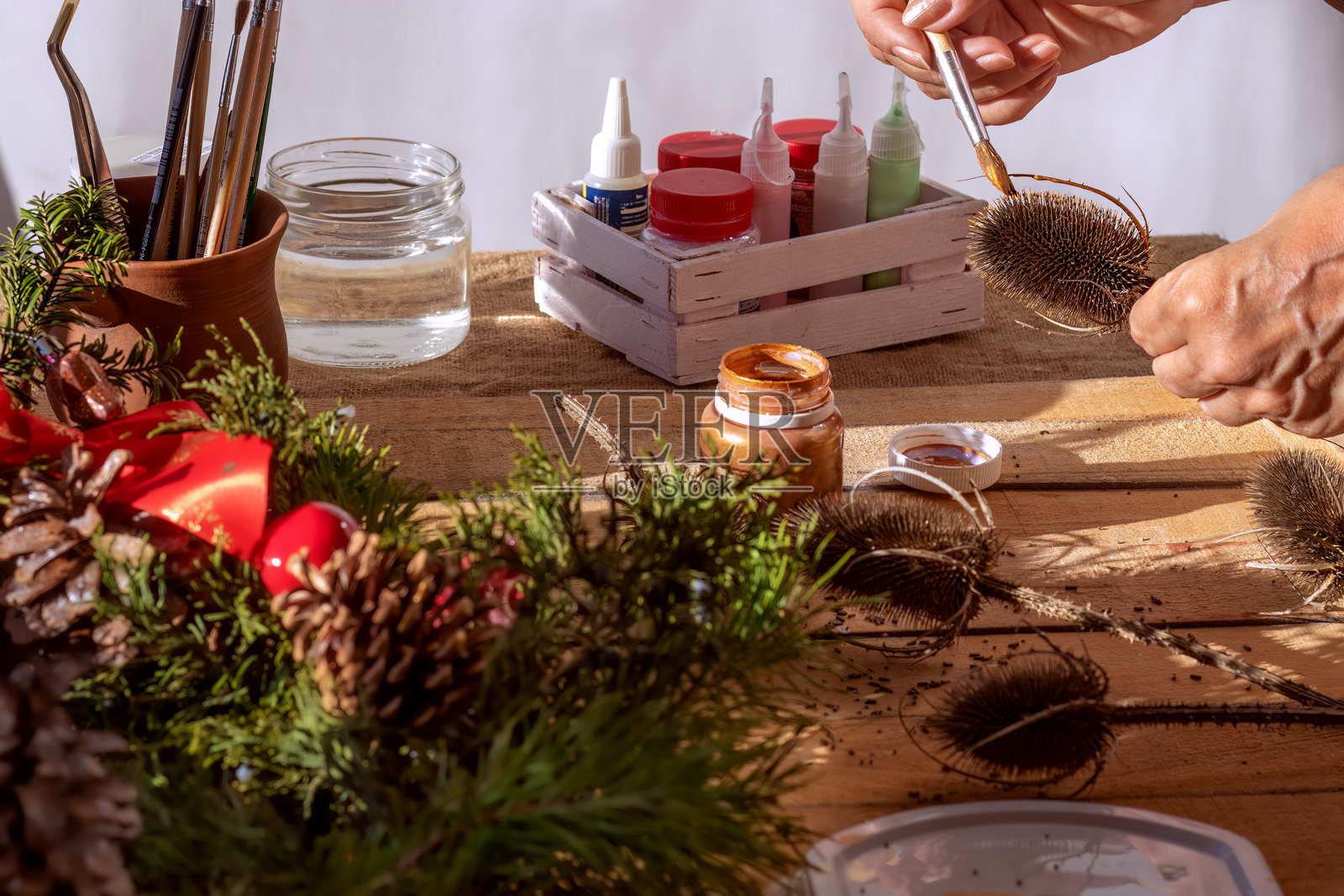 用金色丙烯颜料绘制干花。圣诞花环装饰。照片摄影图片