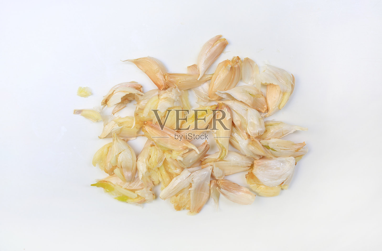 白色背景上的压碎大蒜瓣特写,俯视图。照片摄影图片