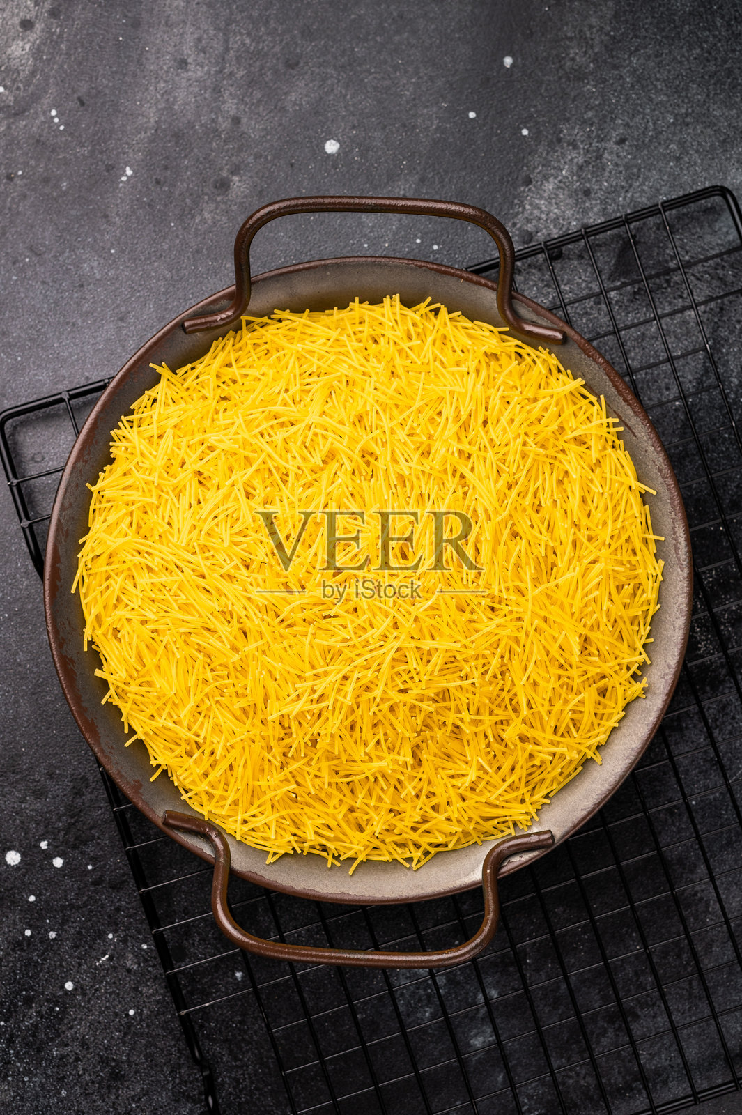 生米粉,未煮的意大利面放在托盘中。黑色背景。俯视图。照片摄影图片