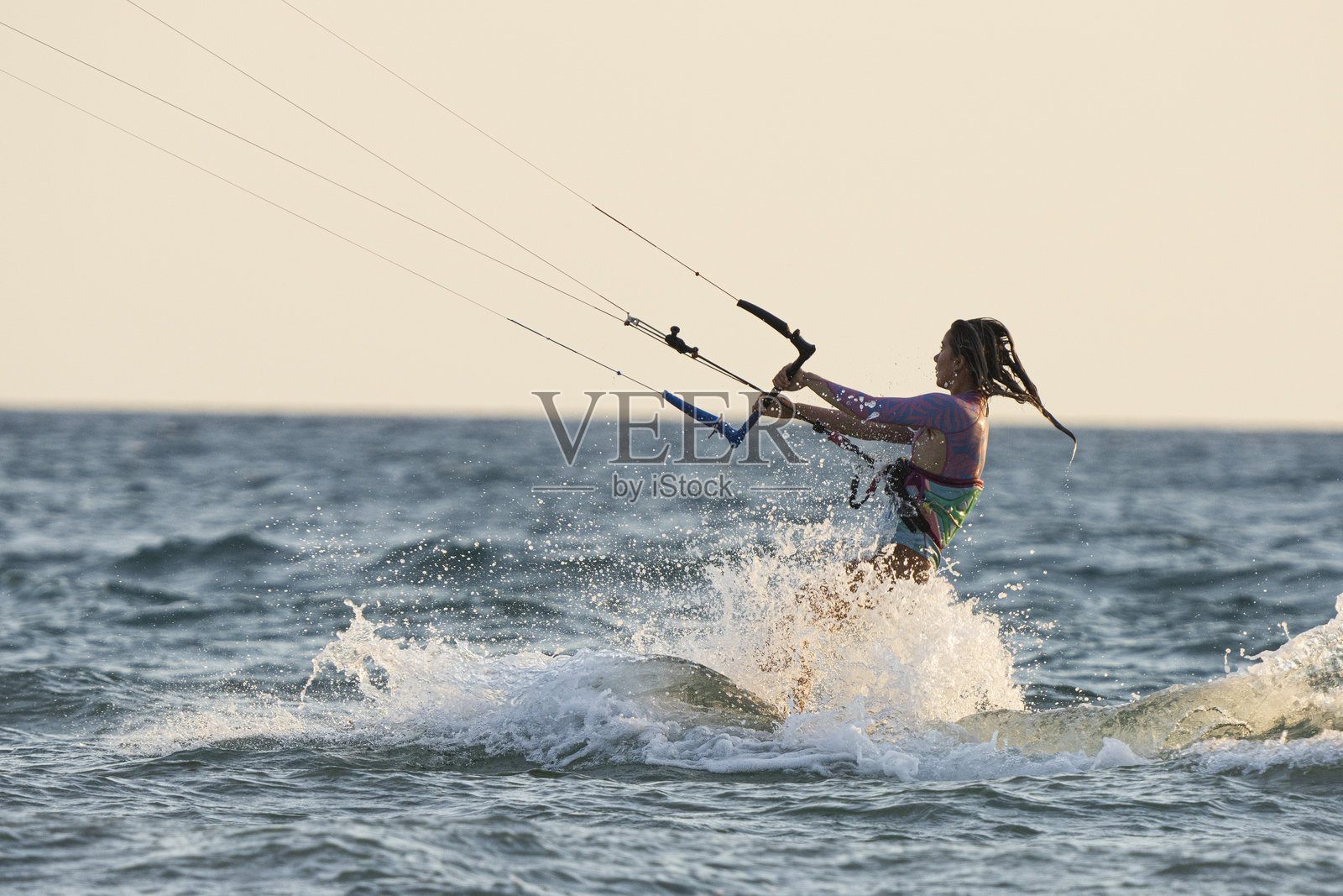 女子在冲浪风筝上骑行照片摄影图片
