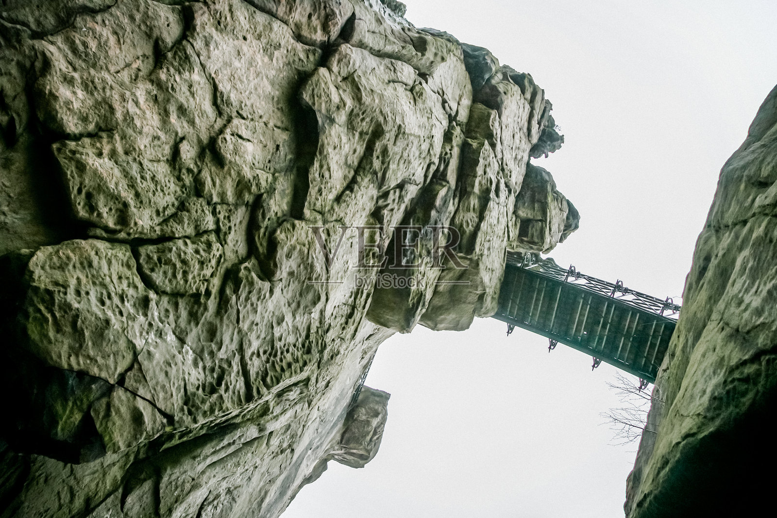 一面岩石墙,旁边有一条通往墙顶的楼梯,位于德国利佩的霍恩-巴德梅因贝格附近的维姆贝克谷。照片摄影图片