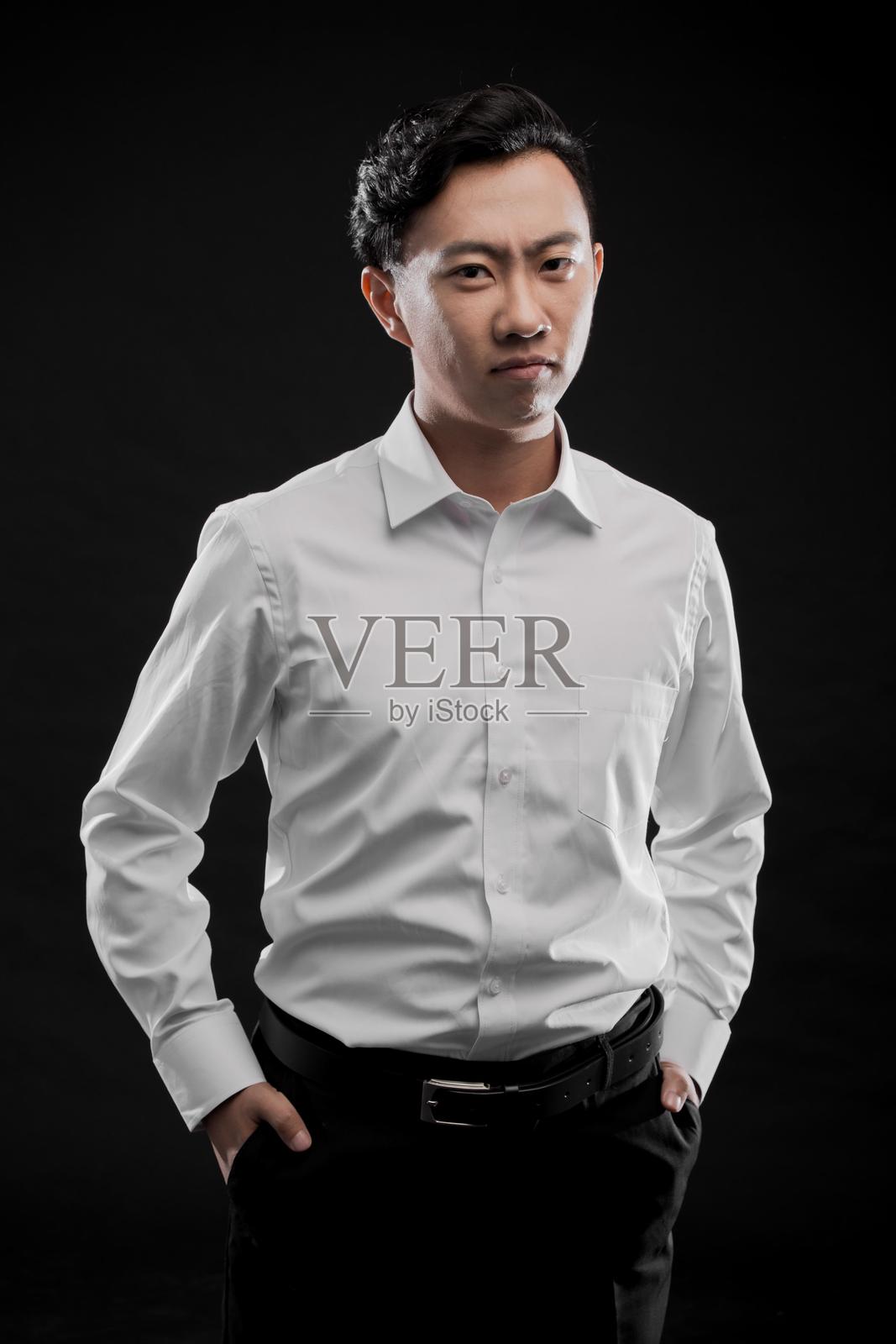 年轻亚洲商人的肖像,穿着白衬衫和黑裤子照片摄影图片