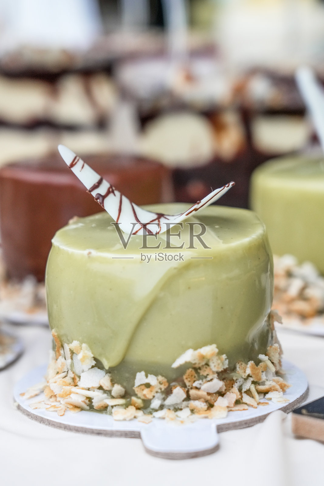 装饰精美的小蛋糕,上面放着开心果,摆放在桌子上照片摄影图片