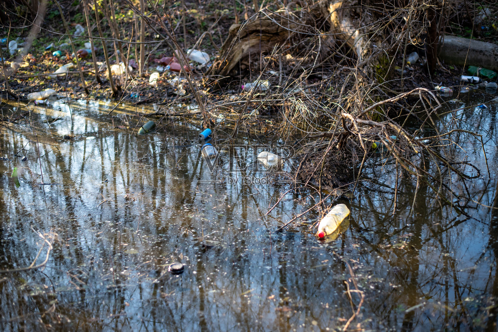 湖泊中的塑料瓶污染。环境影响照片摄影图片
