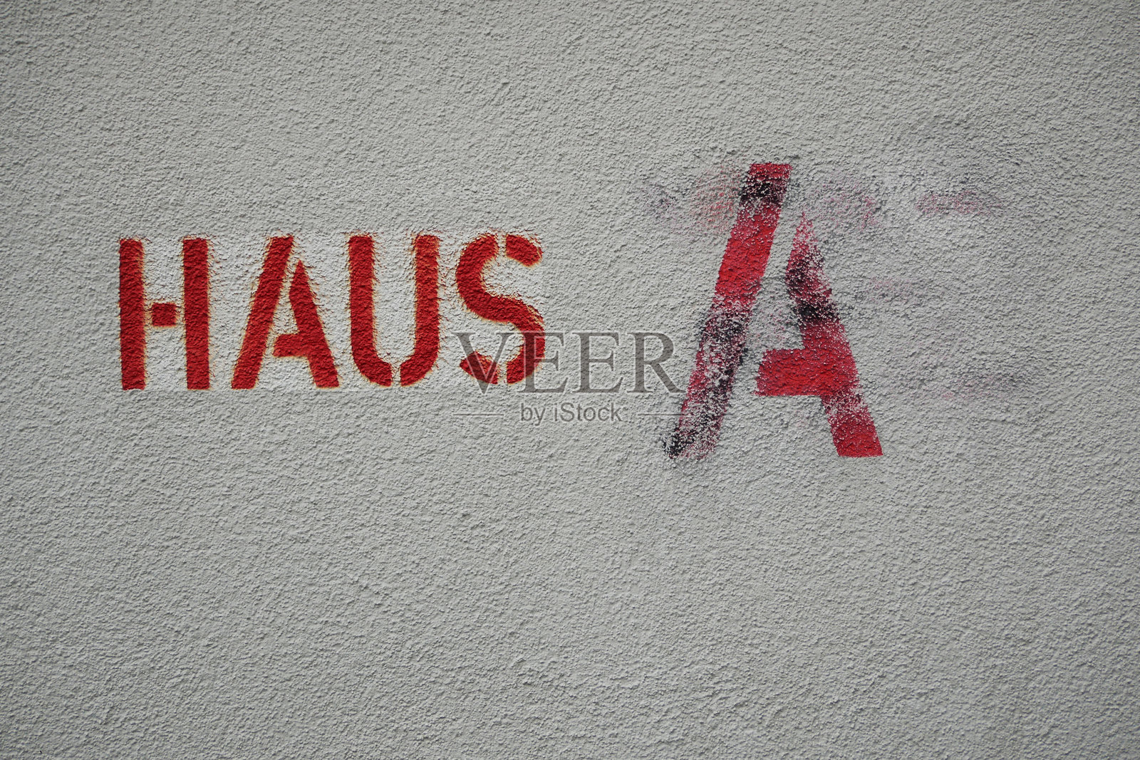 “房子A”用德语红色字母写在白色墙壁上照片摄影图片