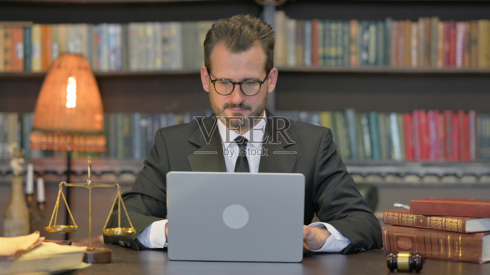 中年律师在办公室使用笔记本电脑工作照片摄影图片