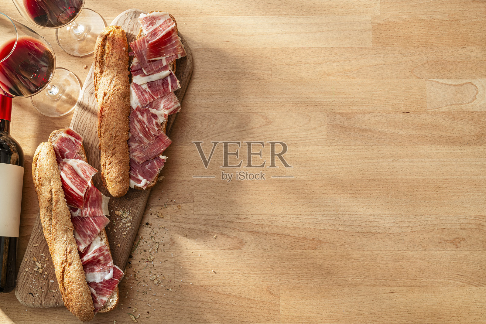 西班牙美食:伊比利亚火腿三明治和红酒放在木桌上。留白空间。照片摄影图片
