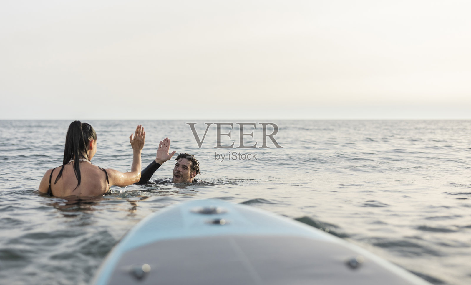 朋友们在海上庆祝成功的冲浪时光照片摄影图片