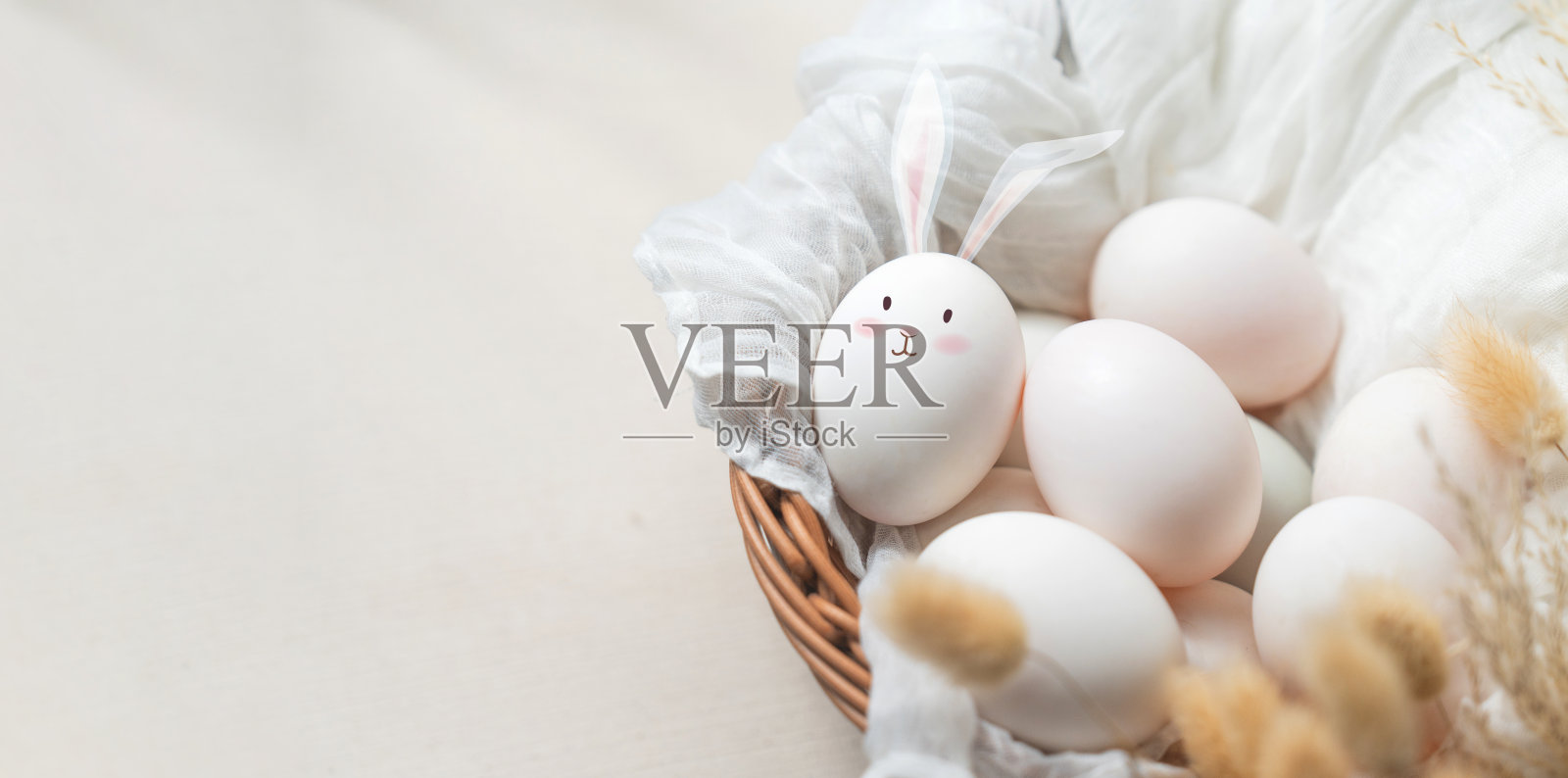 篮子里有兔子耳朵和兔子脸的图画。照片摄影图片