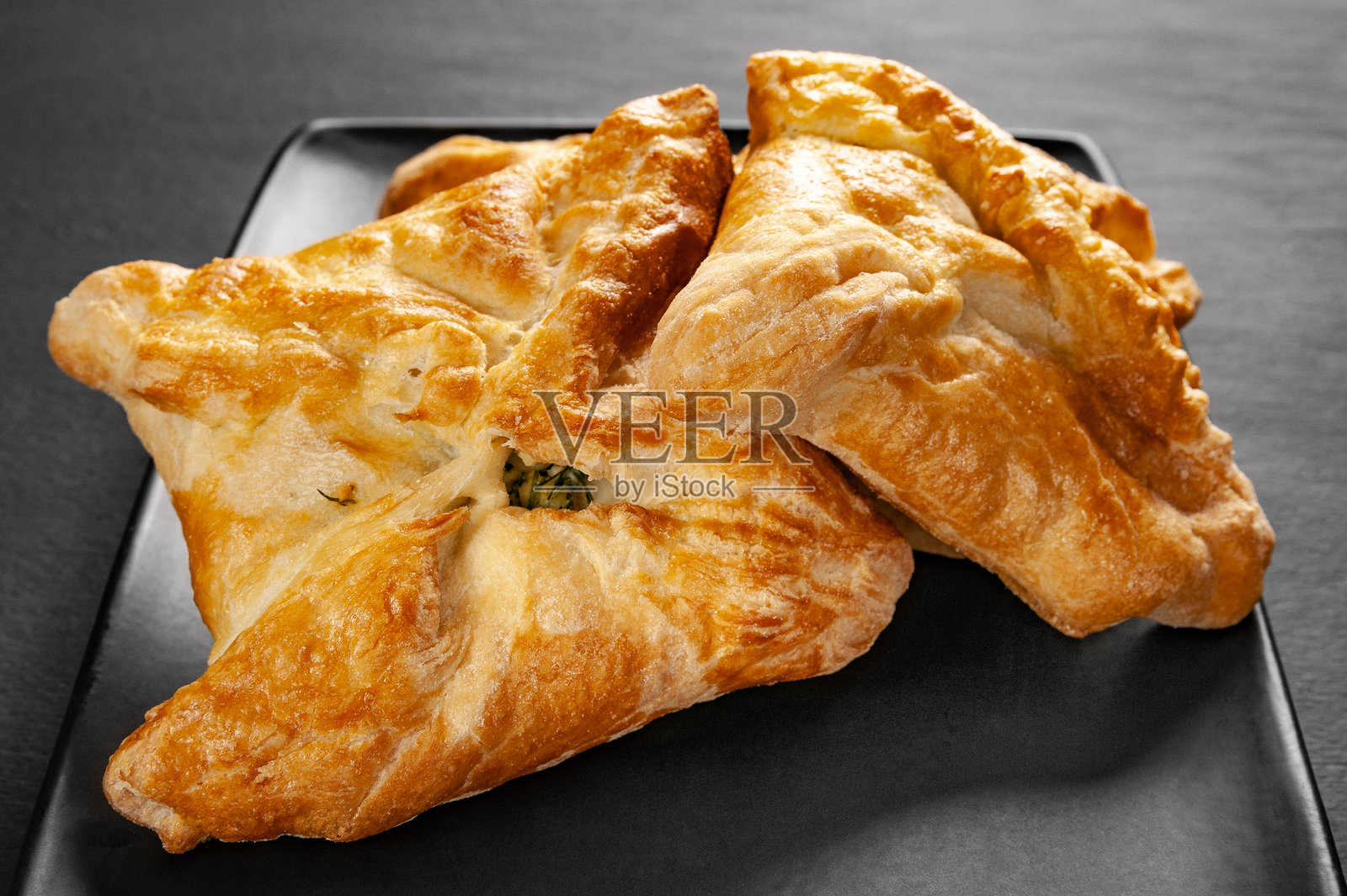 新鲜的蔬菜馅包子。黑暗背景上的小麦面包与蔬菜馅。照片摄影图片