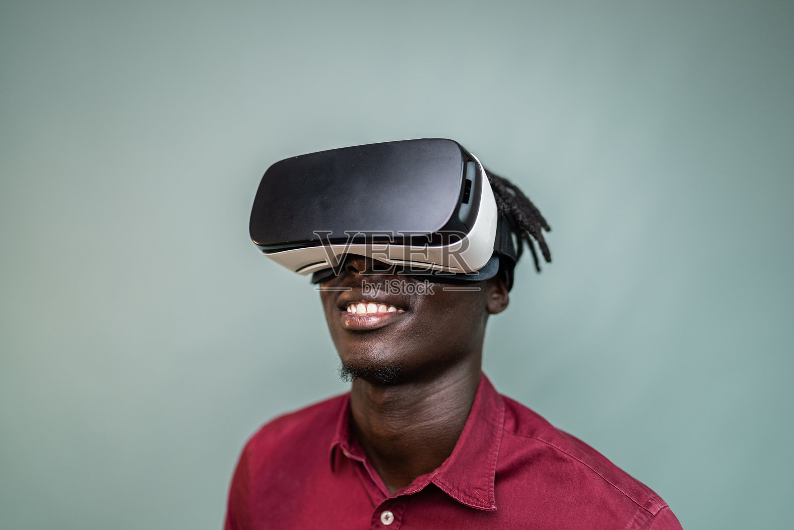 年轻男子在灰色背景下使用虚拟现实眼镜照片摄影图片