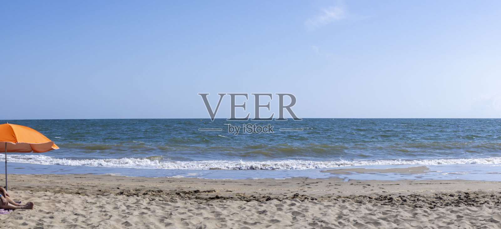 西班牙卡内拉岛海滩上的橙色沙滩伞 - 放松的海岸场景照片摄影图片